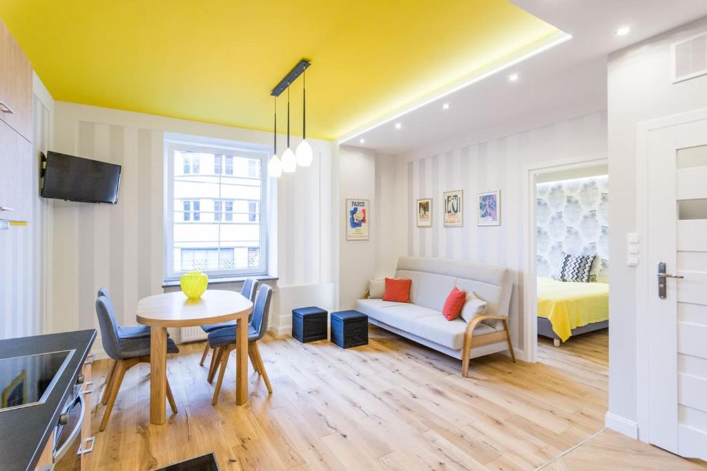 a living room with a table and a couch and a bed at Apartament przy Parku Krakowskim in Kraków