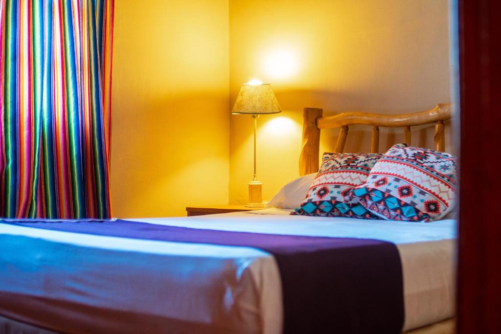 un letto con due cuscini sopra in una stanza di Posada Los Tajibos a Puerto Iguazú