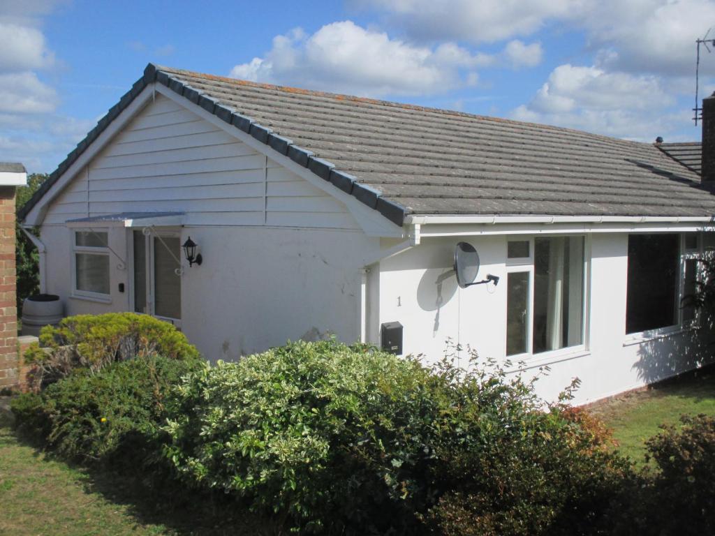 a white house with a gray roof at The Bungalow Lymington 1 mile from New Forest in Lymington