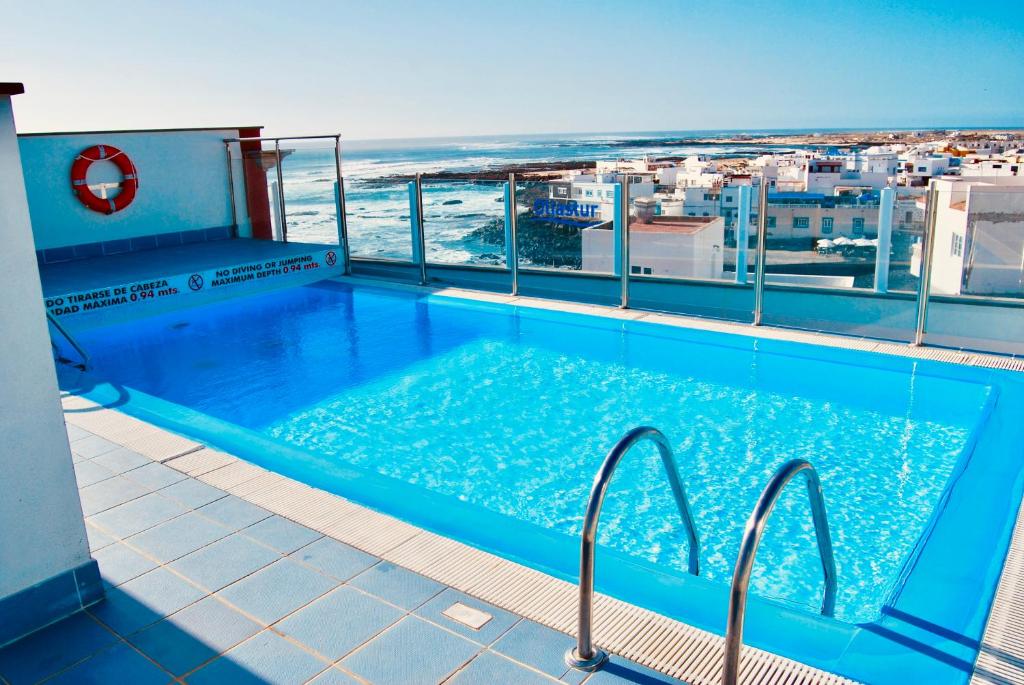 a swimming pool on the roof of a building with the ocean at Casa Yerida in Cotillo