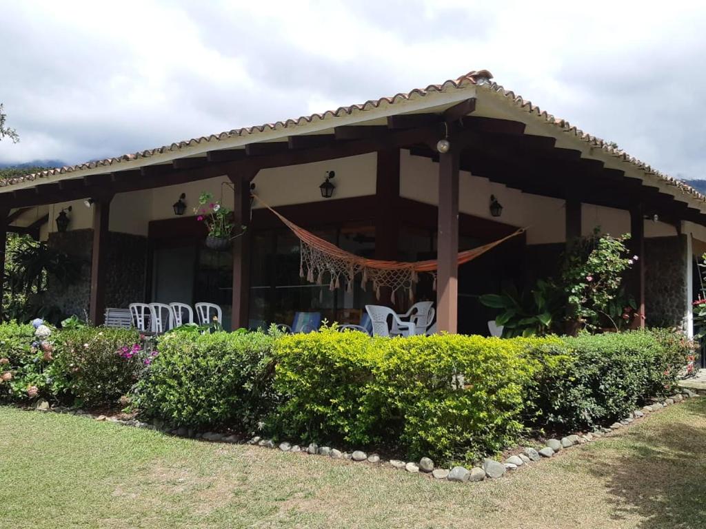 a house with white chairs and a porch at Finca Paraíso in Calima