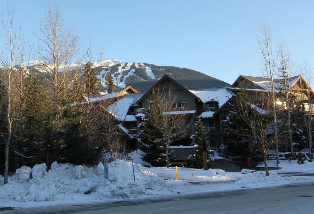 eine Lodge im Schnee mit einem Berg im Hintergrund in der Unterkunft Glacier's Reach by Whistler Retreats in Whistler