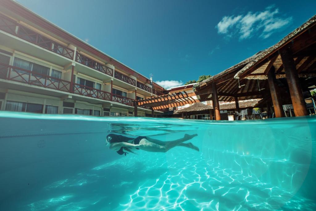 eine Person, die vor einem Hotel im Wasser schwimmt in der Unterkunft Kaiviti Motel in Port Vila