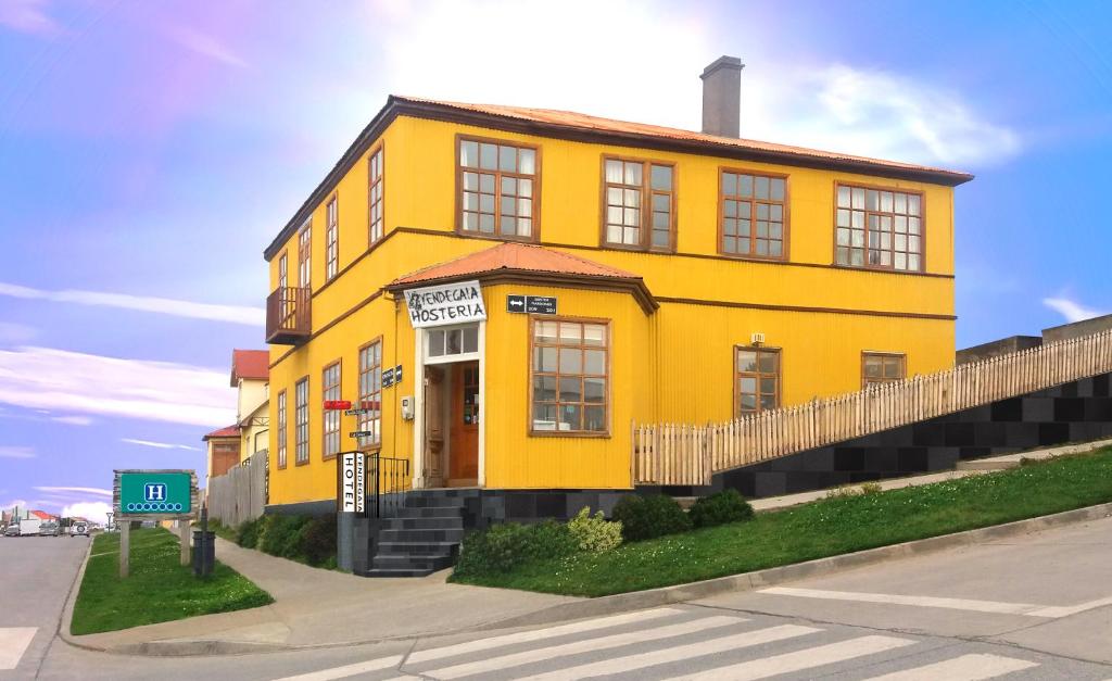 um edifício amarelo no lado de uma rua em Yendegaia House em Porvenir