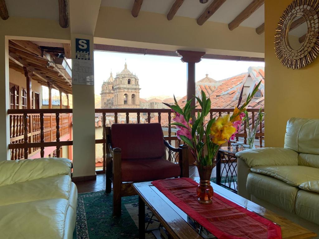 een woonkamer met een tafel en uitzicht op een gebouw bij Amerindia in Cuzco