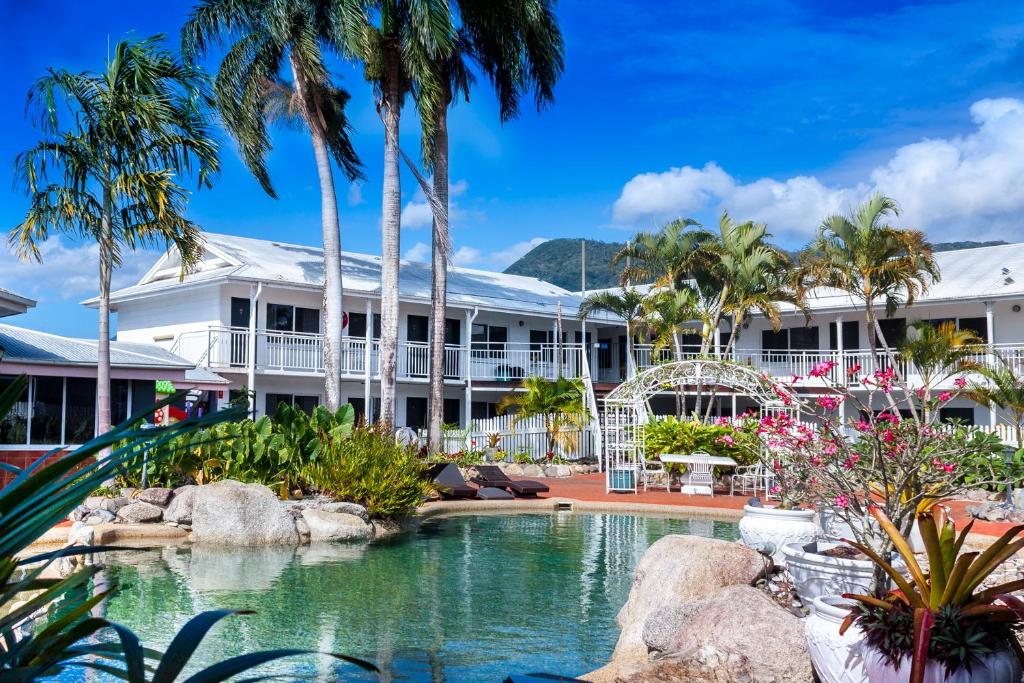 a resort with a pool and palm trees at South Cairns Resort in Cairns