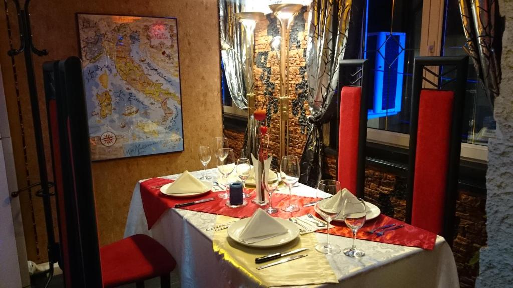 a table with wine glasses and napkins on it at Rimini Club Inn & Suites in Shumen