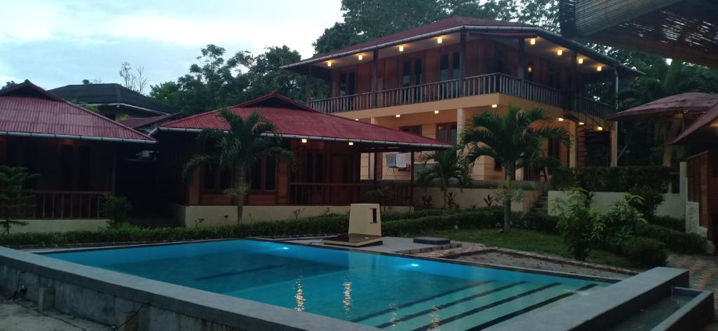 una casa con piscina frente a ella en Cakalang Resort en Bunaken