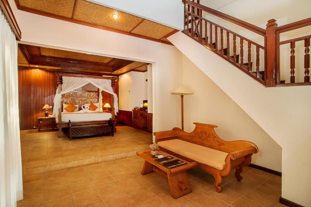 a bedroom with a bed and a stair case at Sri Phala Resort & Villa in Sanur