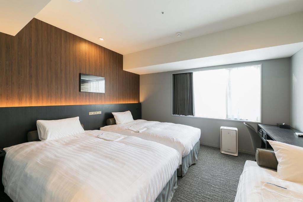 Postel nebo postele na pokoji v ubytování Ginza Capital Hotel Moegi