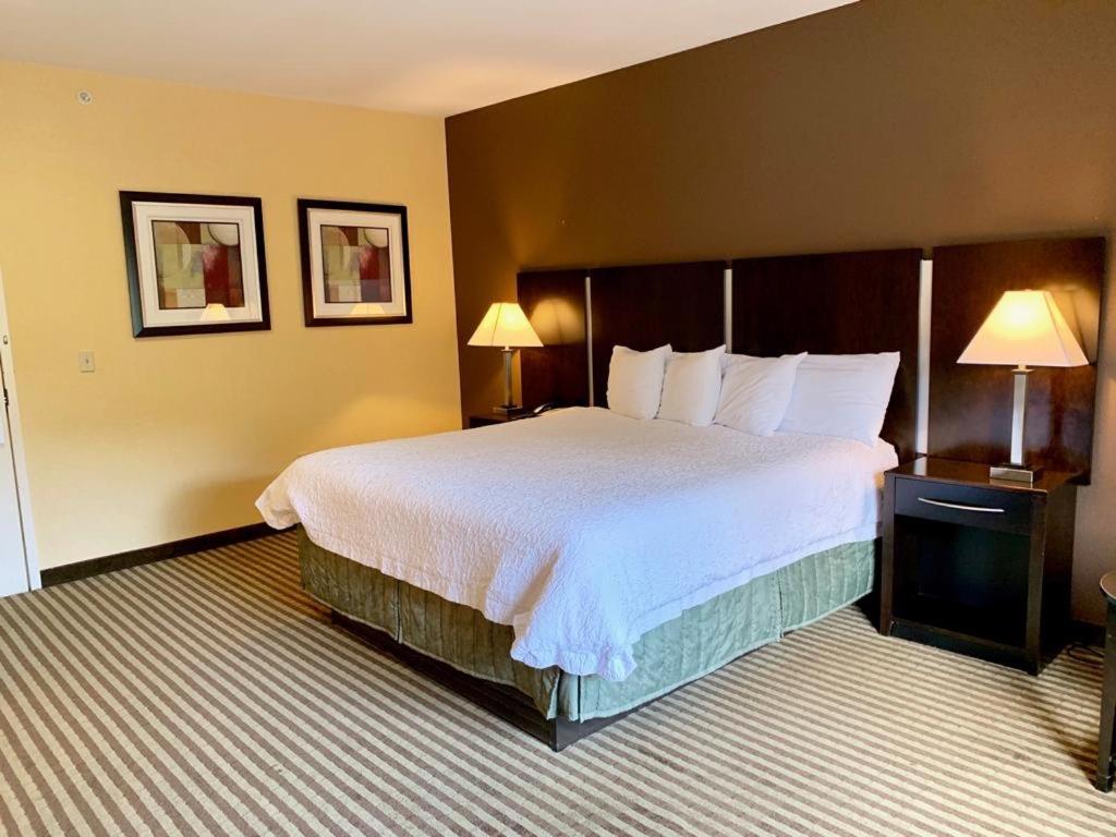 a hotel room with a large bed and two lamps at Whitney Inn & Suites in Hamden
