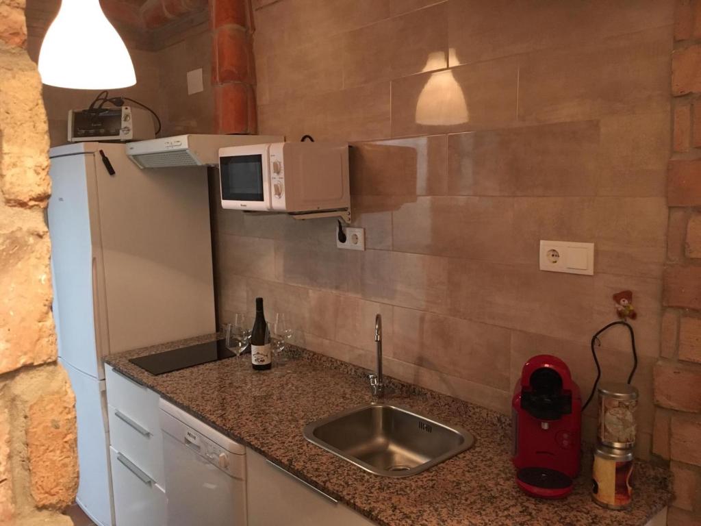 a small kitchen with a sink and a microwave at Casa Maria in Rota