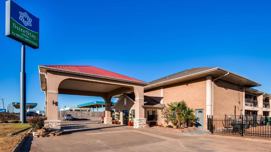 a gas station with a sign in front of it at SureStay Hotel by Best Western Terrell in Terrell