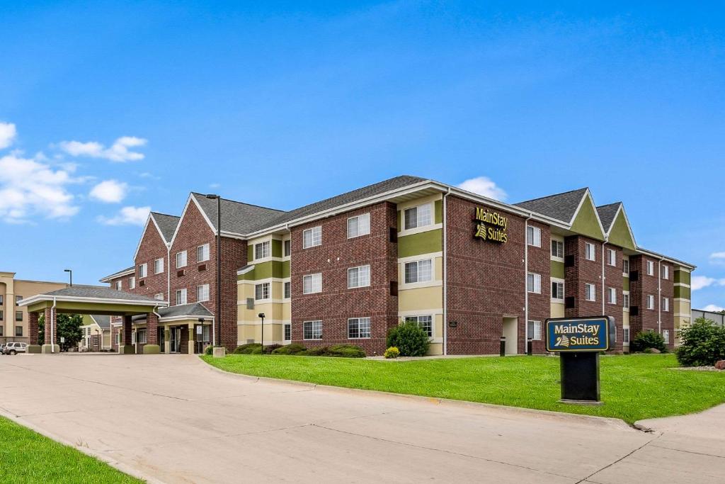 a large brick building with a sign in front of it at MainStay Suites Cedar Rapids North - Marion in Cedar Rapids