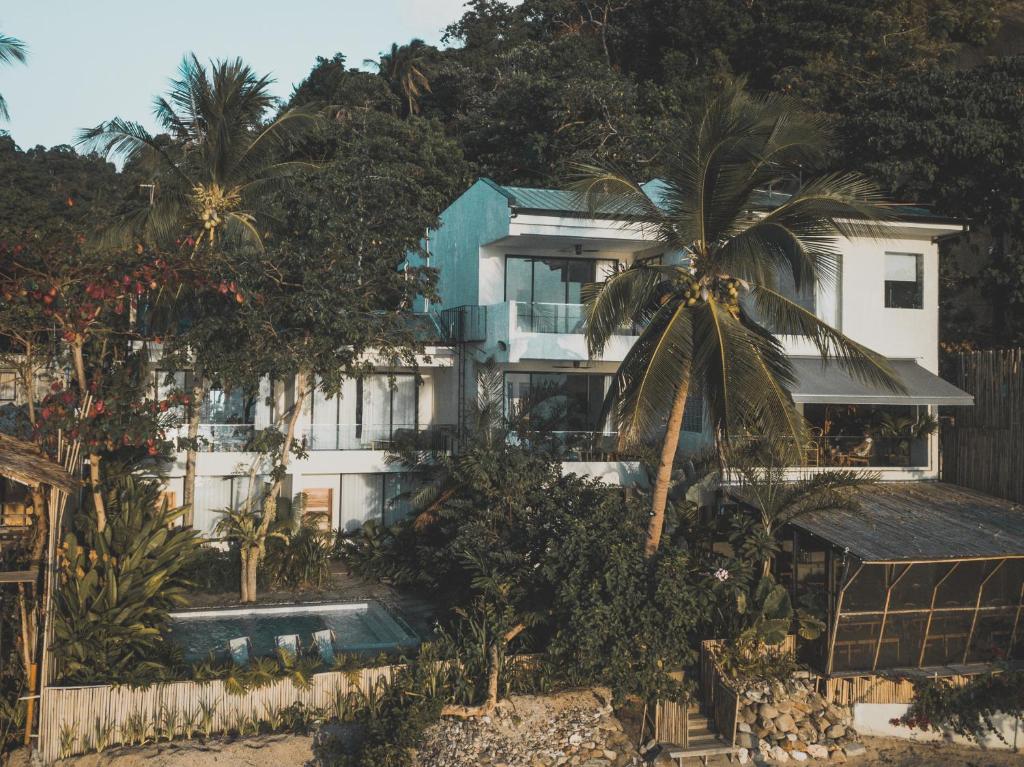 a building with a palm tree in front of it at Frangipani El Nido in El Nido