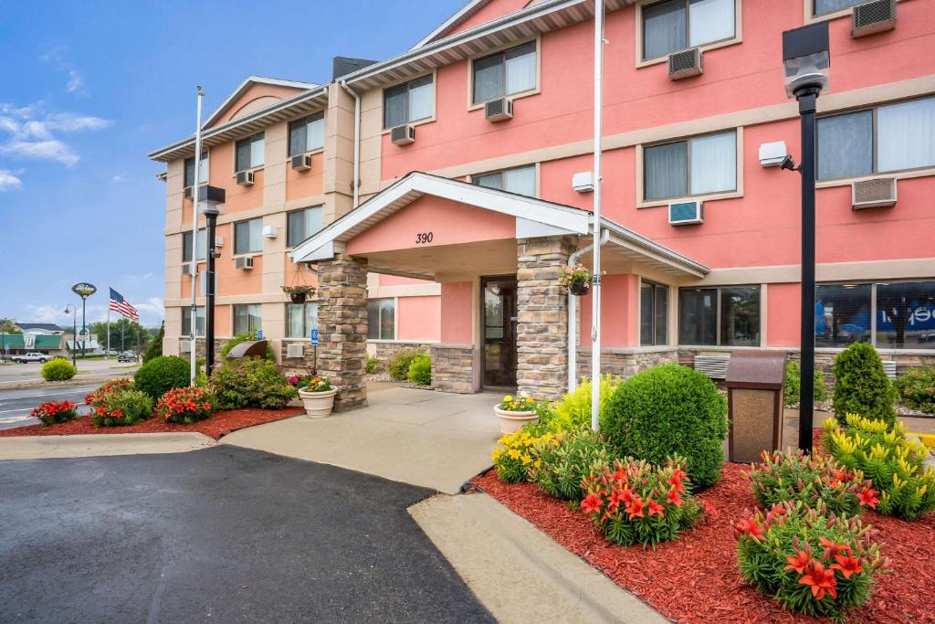 un gran edificio rosa con flores delante en Quality Inn Cedar Rapids South, en Cedar Rapids