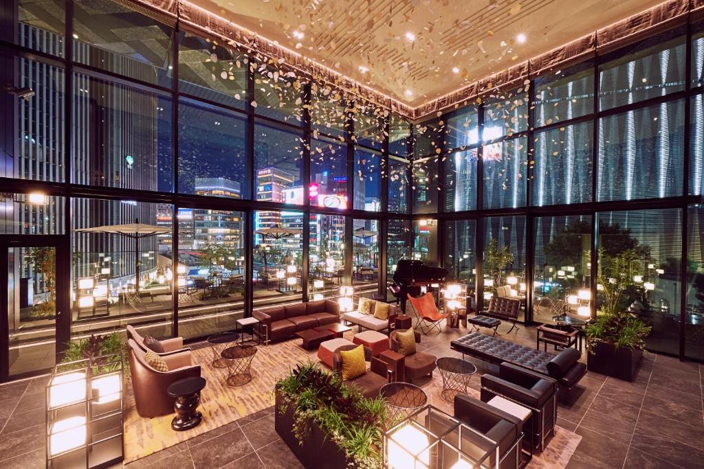 a lobby with a view of a city at night at The Gate Hotel Tokyo by Hulic in Tokyo