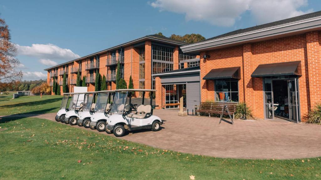 einem Golfwagen, der vor einem Backsteingebäude parkt in der Unterkunft Country Club Tasmania in Launceston