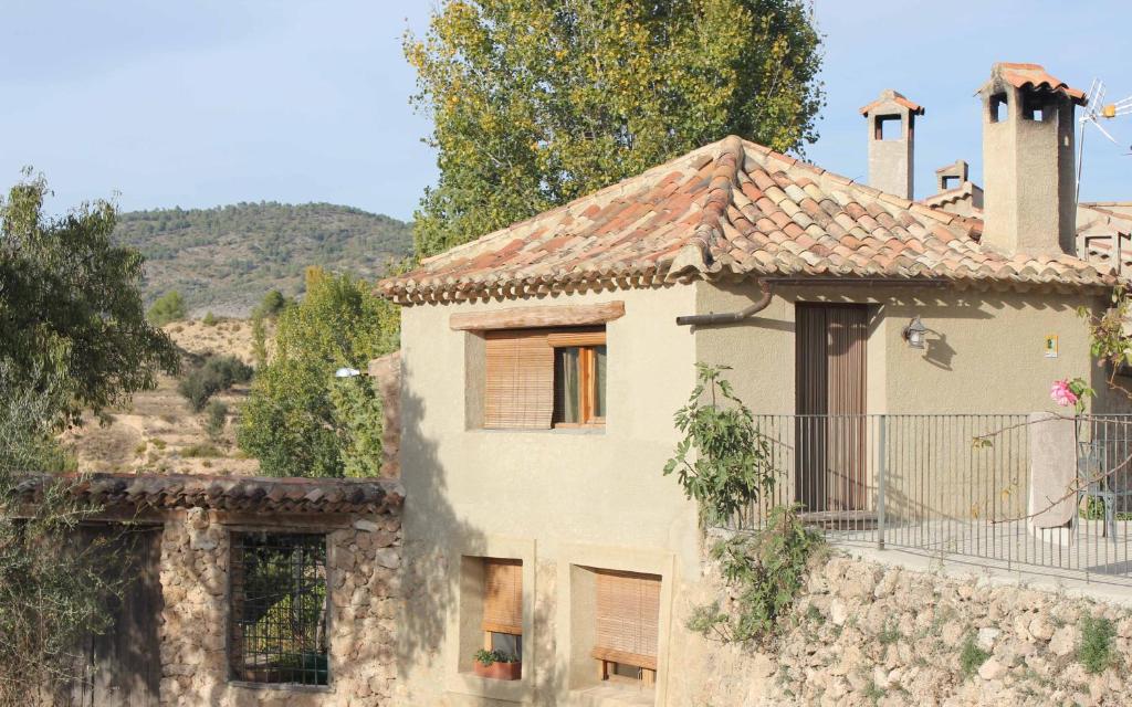 Casa de piedra antigua con balcón en una colina en Agroturismo La Artezuela, en Letur