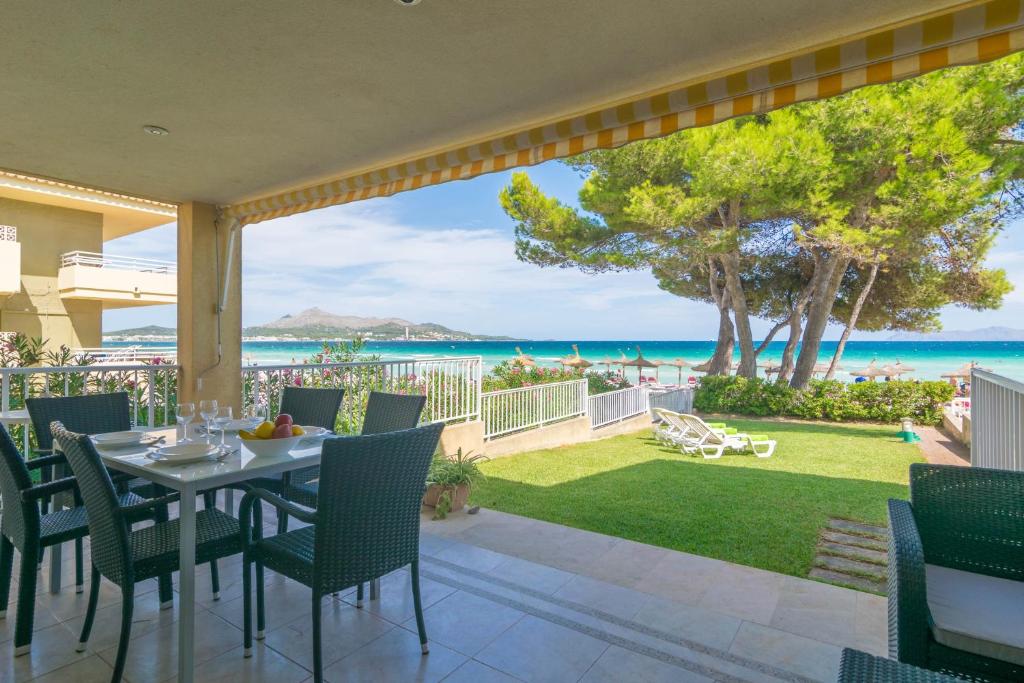 a patio with a table and chairs and a view of the ocean at Chillvista in Playa de Muro