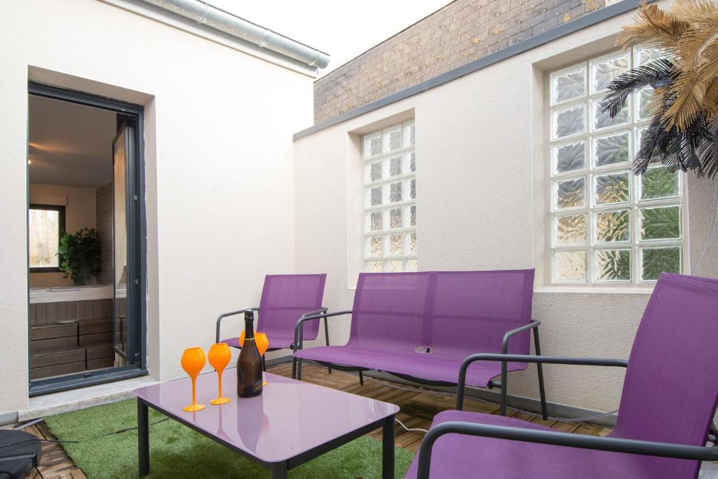 エペルネーにあるVilla D'Aÿ-Champagneの紫色の椅子とテーブルが備わるパティオ
