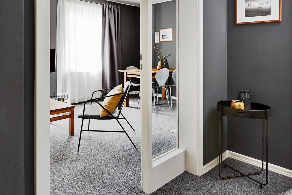 een spiegel in een kamer met een tafel en een stoel bij STAY Boardinghouse Flottbek in Hamburg