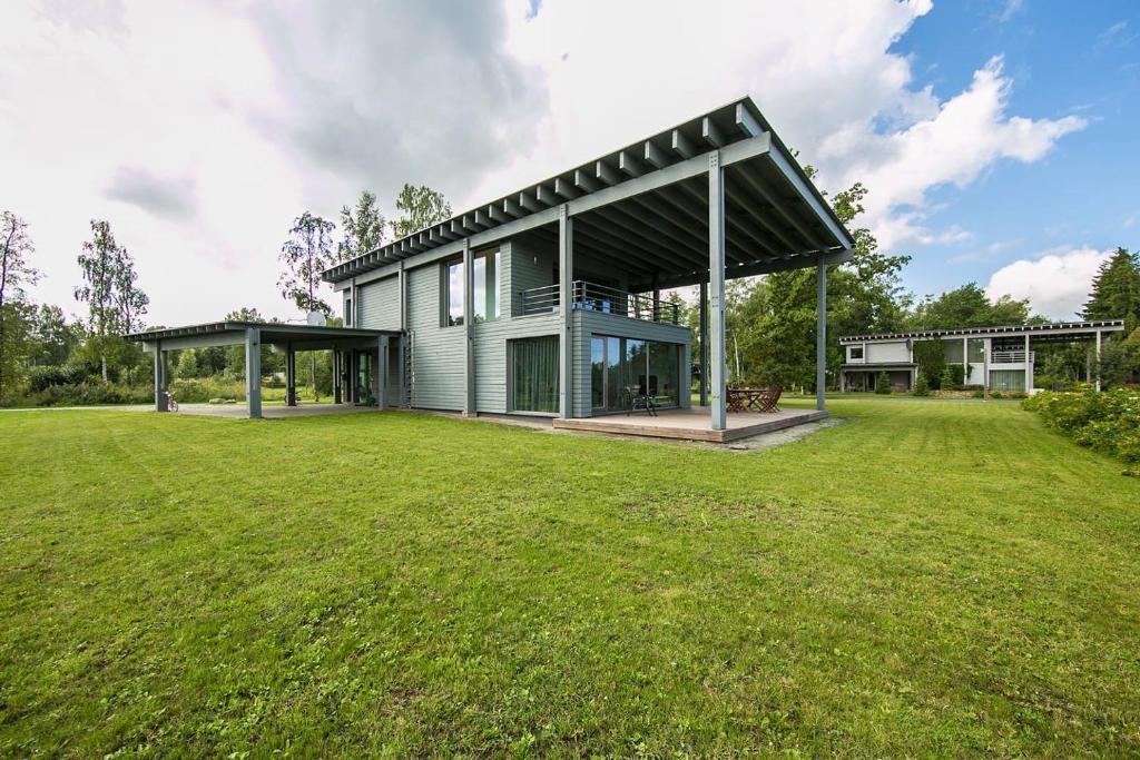 une maison avec une grande cour devant elle dans l'établissement Golf Villa near Tallinn, à Manniva