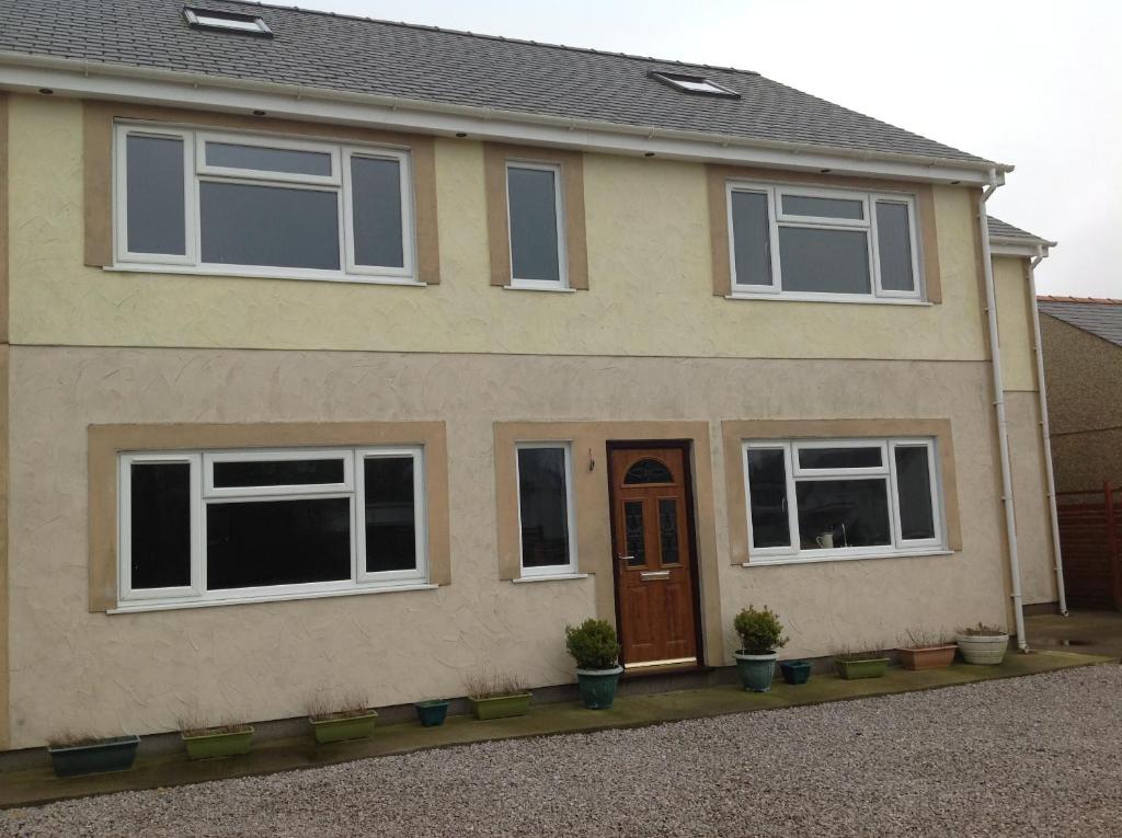 a house with windows and a brown door at Criw Newydd in Bryncroes