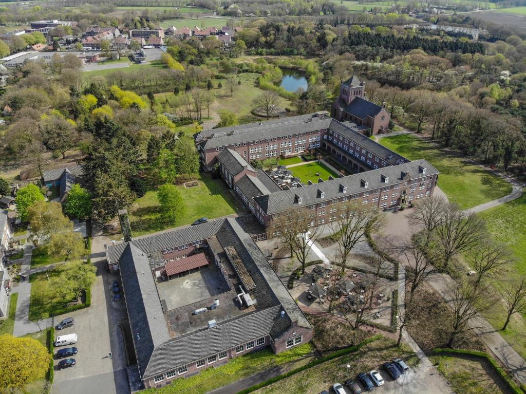 una vista aérea de un edificio con patio en Fletcher Kloosterhotel Willibrordhaeghe en Deurne