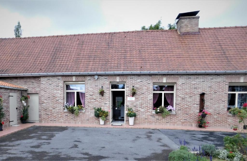 a brick building with a parking lot in front of it at Chambre du Hamel in Avroult