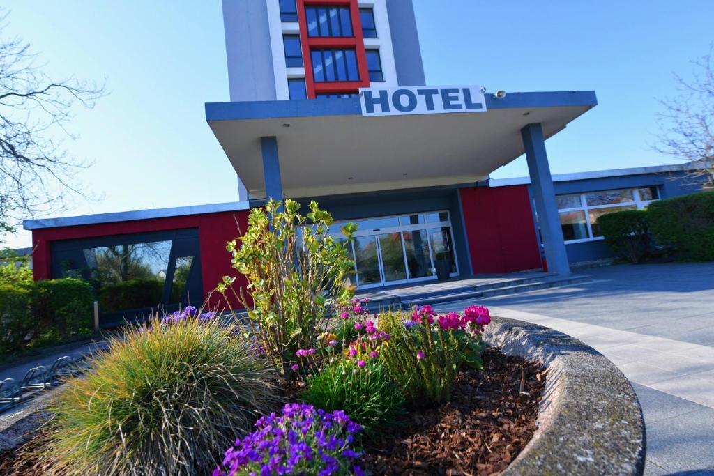 ein Hotel mit Blumen vor einem Gebäude in der Unterkunft SKYHOTEL Merseburg in Merseburg