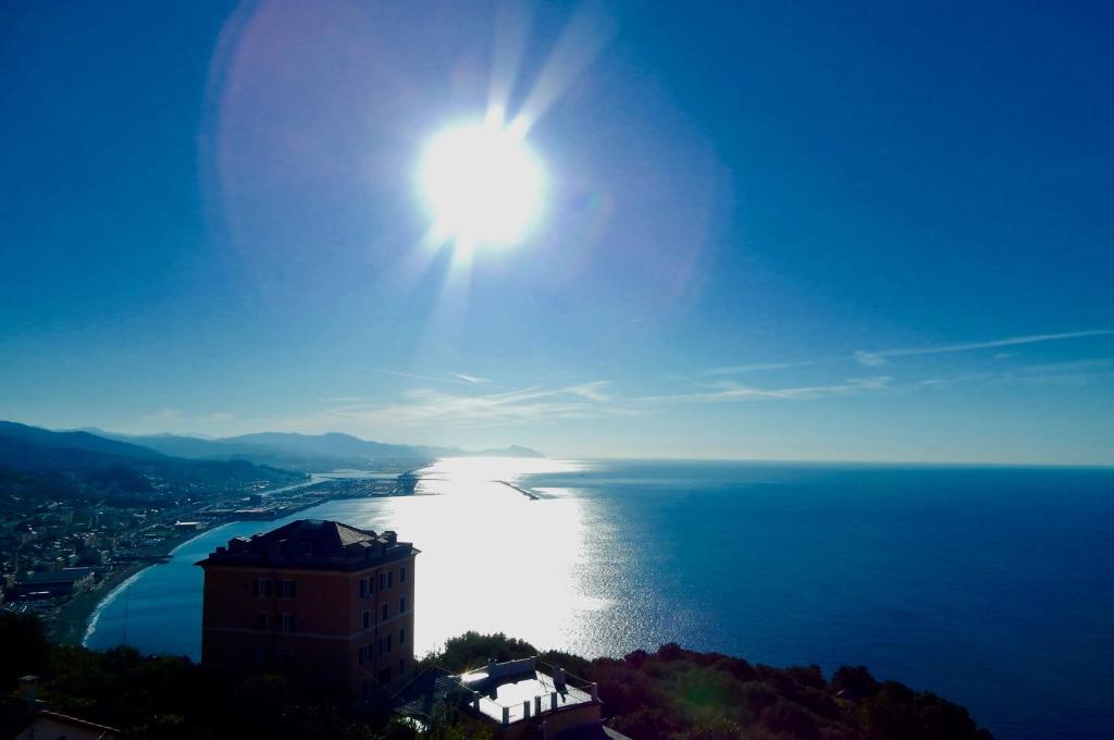 a view of the ocean with the sun in the sky at LE GIÜE in Genoa