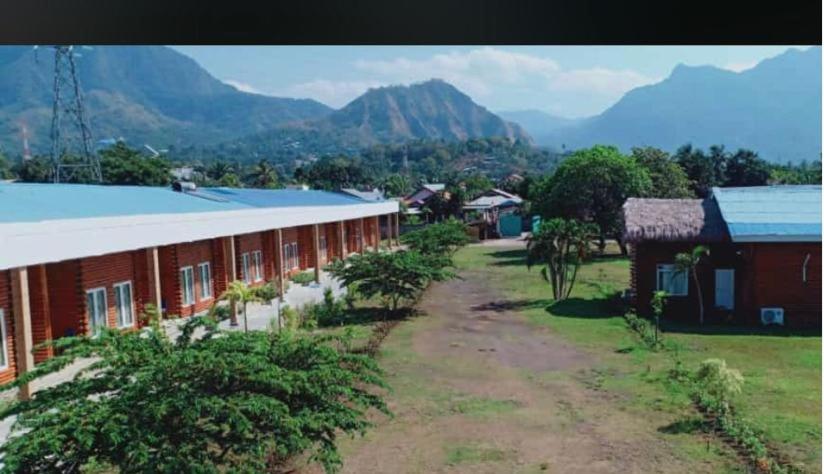 a group of buildings with mountains in the background at GLOBAL VIEW HOTEL in Ende