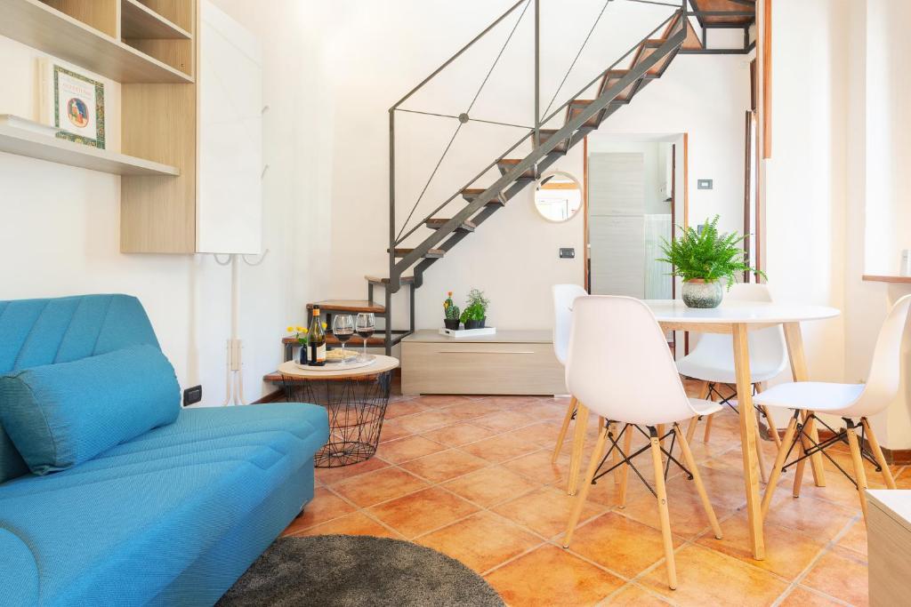 ein Wohnzimmer mit einem blauen Sofa und einem Tisch in der Unterkunft Duplex Apartment in pieno centro in Ferrara