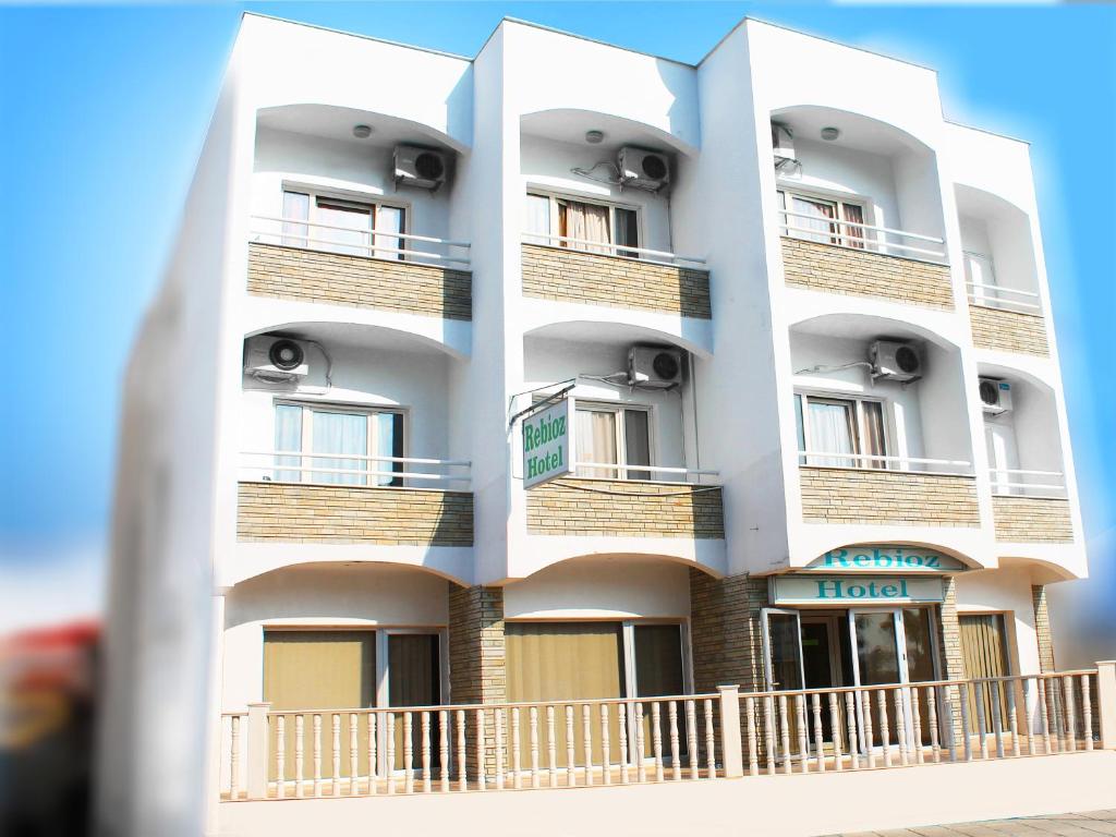 a white building with balconies on the side of it at Rebioz Hotel in Larnaca