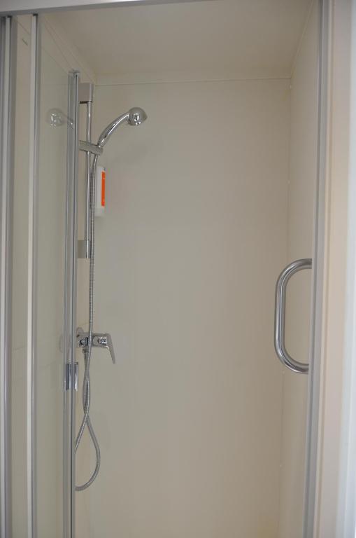 um chuveiro numa casa de banho com uma porta de vidro em easyHotel Zürich West em Zurique