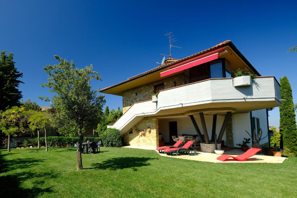 una casa con sillas rojas delante en Il Melograno - San Quirico d'Orcia, en San Quirico dʼOrcia