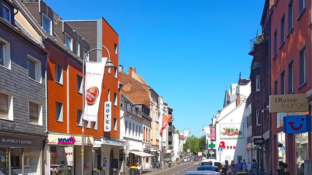 une rue urbaine avec des bâtiments et des voitures garés dans la rue dans l'établissement Hotel Gertrudenhof, à Cologne