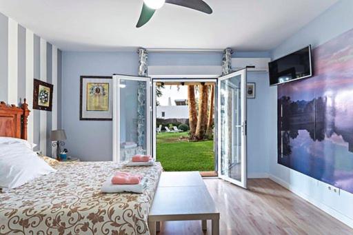アグアドゥルセにあるVilla los Alamosのベッドルーム1室(ベッド1台付)、スライド式ガラスドアが備わります。