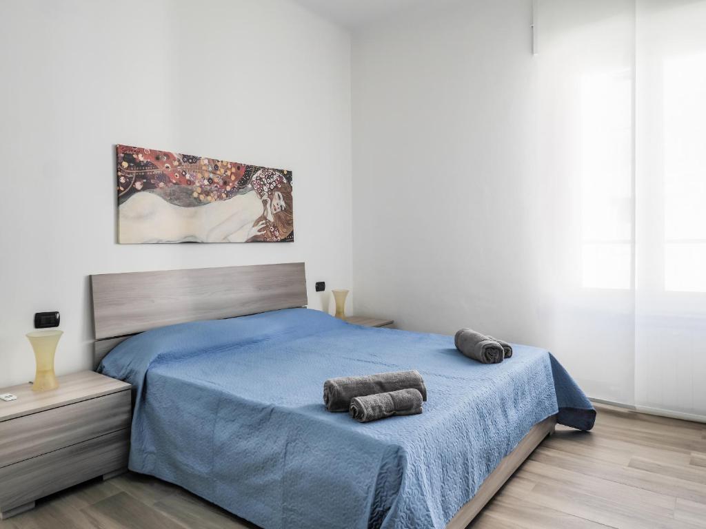 1 dormitorio con 1 cama azul y 2 toallas en Brand New Cinque Terre Cozy Flat, en La Spezia