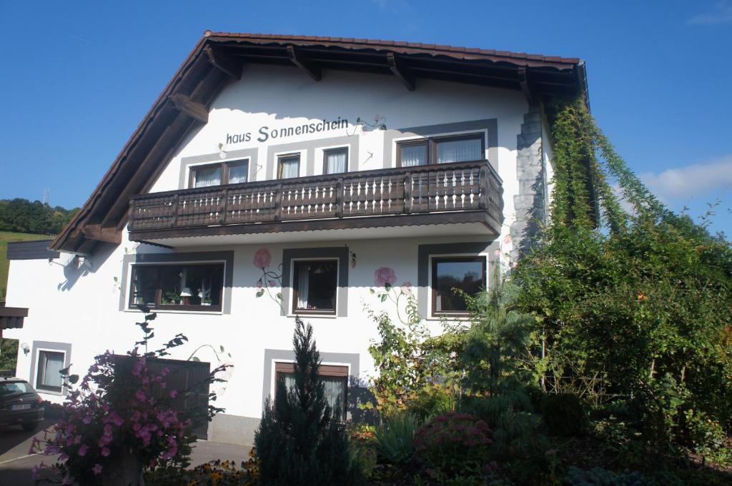 een wit gebouw met een balkon aan de zijkant bij Haus Sonnenschein in Mespelbrunn