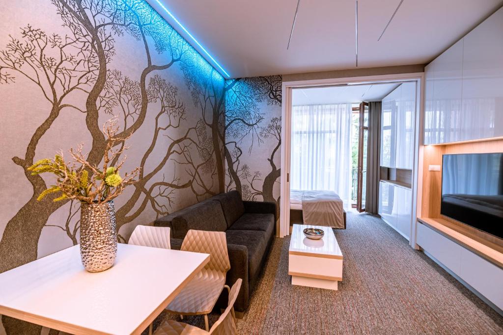 a living room with a tree mural on the wall at Apartment Luna Hrebienok D2 in Smokovce