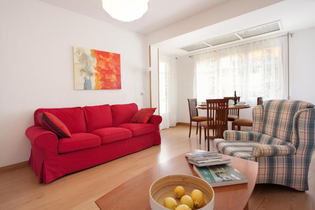 sala de estar con sofá rojo y mesa en Click&Flat Floridablanca, en Barcelona