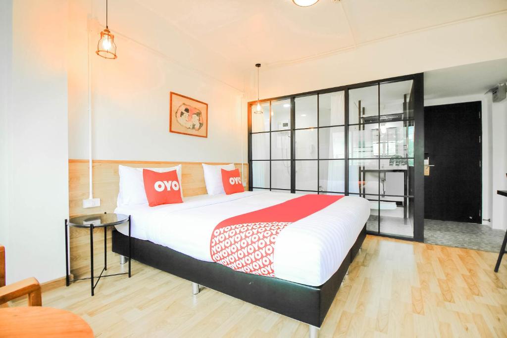1 dormitorio con 1 cama grande con almohadas rojas y blancas en Super OYO 275 Kailub Capital O, en Lat Krabang