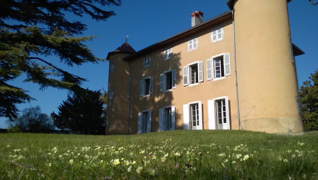 una casa vieja en una colina con flores en Château La Violette en Les Marches