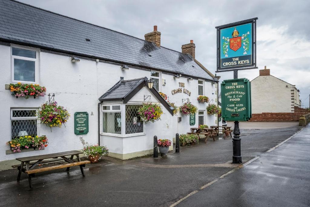 a white building with a sign in front of it at The Cross Keys in Esh