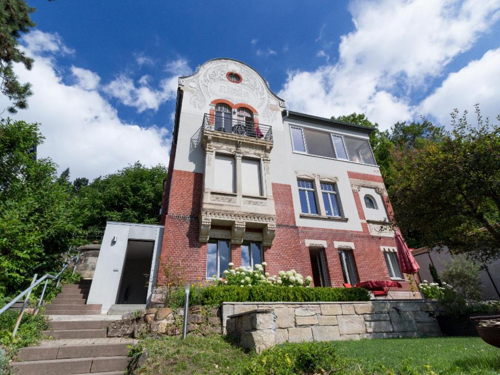 ein altes Backsteingebäude mit einem Uhrturm in der Unterkunft Ferienwohnung Villa Elisabeth in Erfurt