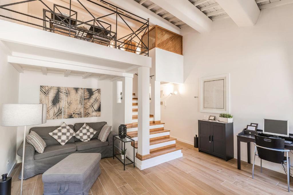ein Wohnzimmer mit einem Sofa und einem Loft in der Unterkunft Thebestinrome Orbitelli in Rom