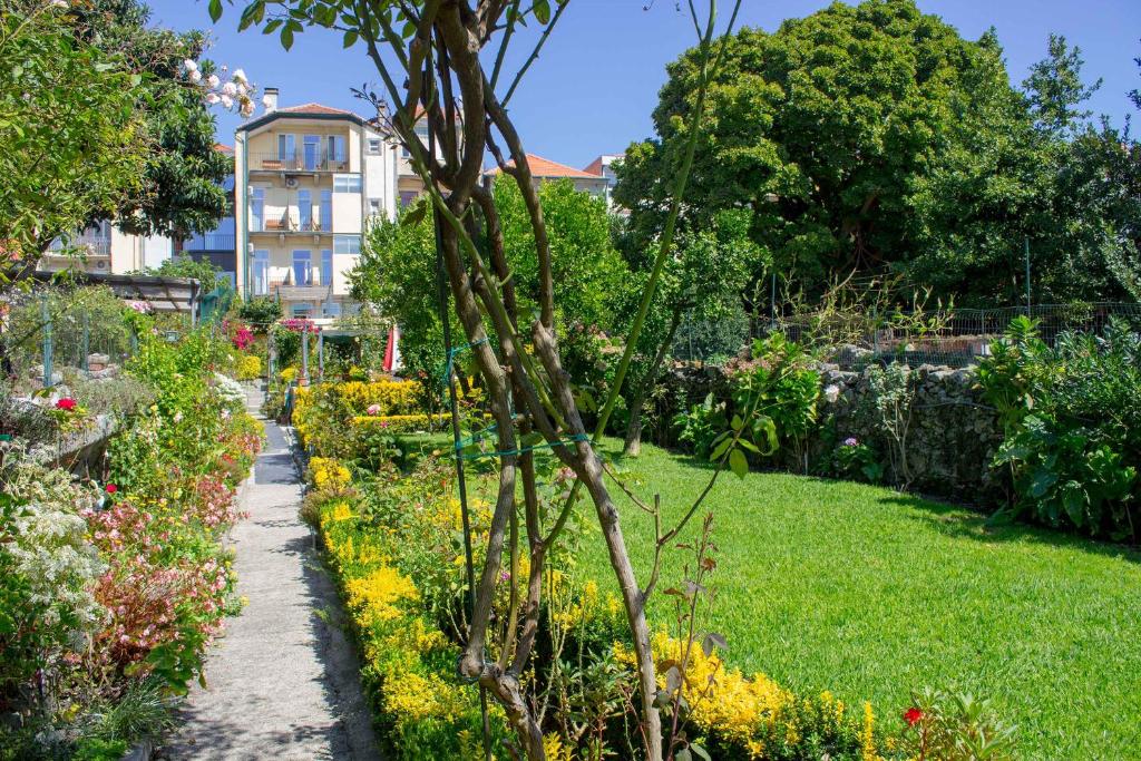 a garden with flowers and a building in the background at Hotel Estoril Porto in Porto