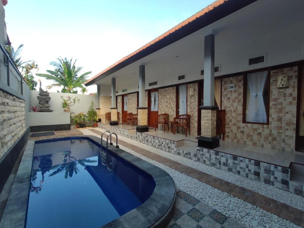 a swimming pool in front of a house at Gedhong Hostel in Nusa Penida